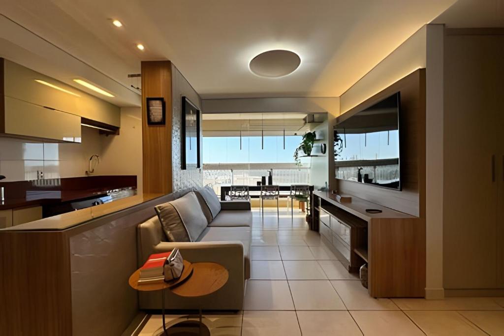 a kitchen and living room with a couch and a table at iFlat Winner Sport Life Jardim Goiás in Goiânia