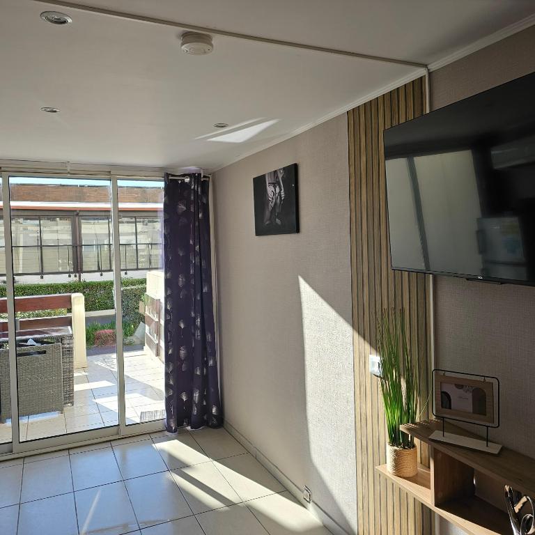 un salon avec une télévision à écran plat sur un mur dans l'établissement Naturiste Port Nature, au Cap d'Agde