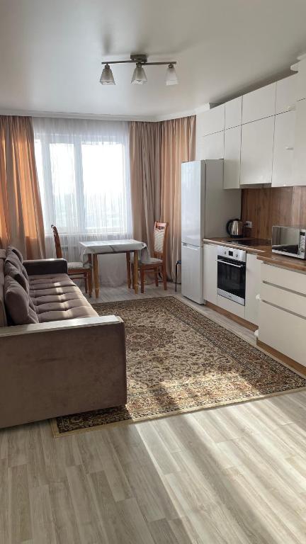 een keuken en woonkamer met een bank en een tafel bij БЦ Алматы, иманова-валиханова in Astana