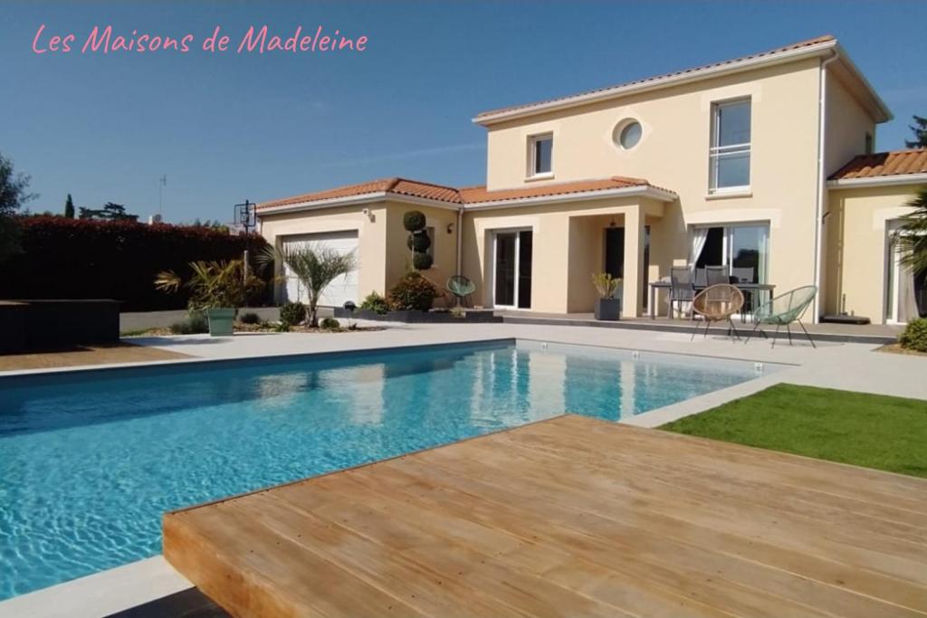 une villa avec piscine devant une maison dans l'établissement Exclusivité - La Perle Bleue, à La Chevrolière
