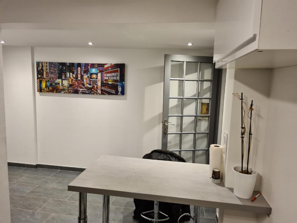 une table dans une pièce avec une photo sur le mur dans l'établissement Maison en centre ville, à Cormeilles-en-Parisis