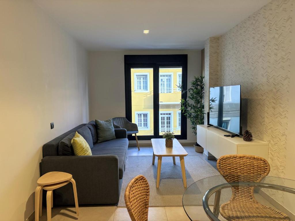 ein Wohnzimmer mit Sofa und Fernseher in der Unterkunft Las Canteras Deluxe in Las Palmas de Gran Canaria