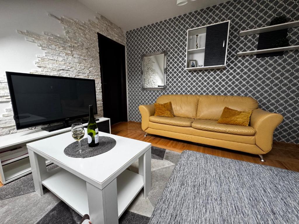 Una sala de estar con un sofá y un televisor. en Apartment Meri in Kraljevi Cardaci, en Kopaonik