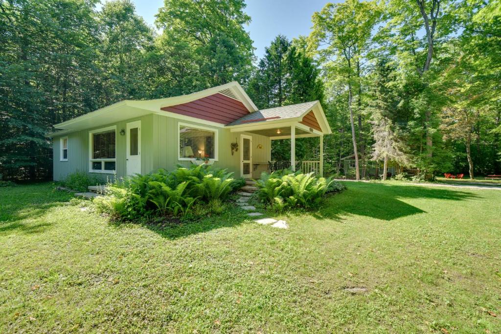 a small house with a red roof in a yard at Cherry Cottage - Walk to Peninsula State Park! in Ephraim