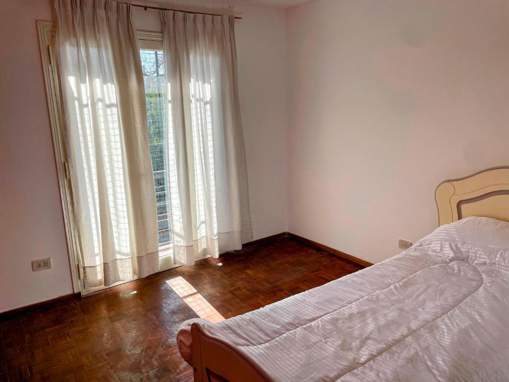 a bedroom with a bed and two large windows at Departamento amplio Zona Centro de Mendoza in Barraquero