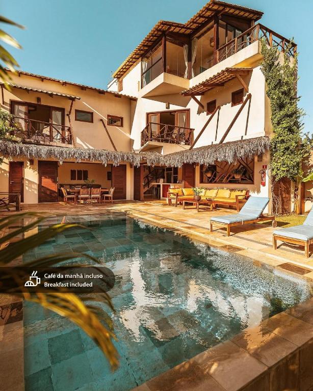 a swimming pool in front of a house at Vila Harmonia sua casa na Praia do Preá in Prea