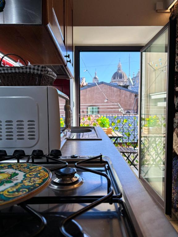 a kitchen with a stove top oven next to a window at Duomo View Apartment in Catania