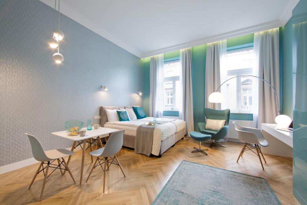 1 dormitorio con 1 cama, mesa y sillas en Apartamenty Pod Orłem, en Cracovia