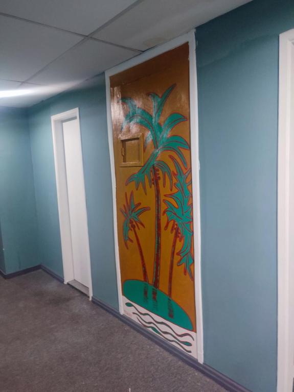 a room with a painting of palm trees on the wall at Hostel Princess Copacabana in Rio de Janeiro