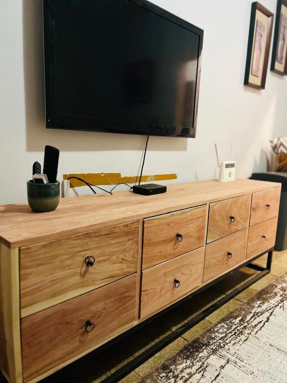 a wooden dresser with a television on top of it at Java Tree Cottage in Lusaka