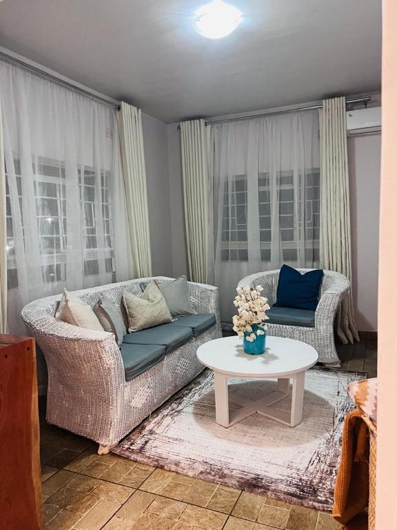 a living room with a couch and a table at Java Tree Cottage in Lusaka