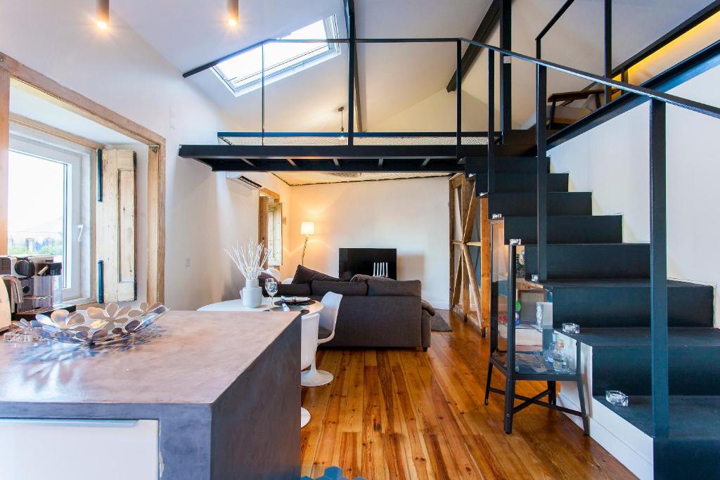 un salon avec un escalier dans un loft dans l'établissement Loft LX factory, à Lisbonne