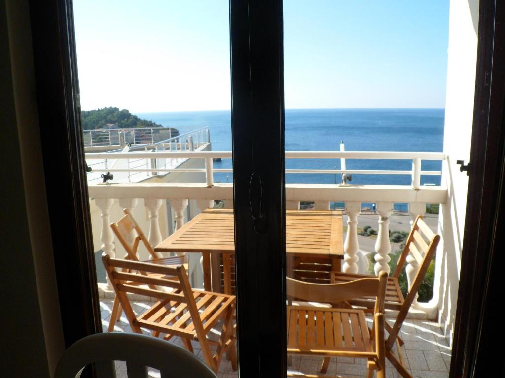 einen Tisch und Stühle auf einem Balkon mit Meerblick in der Unterkunft Milocer Apartment in Sveti Stefan