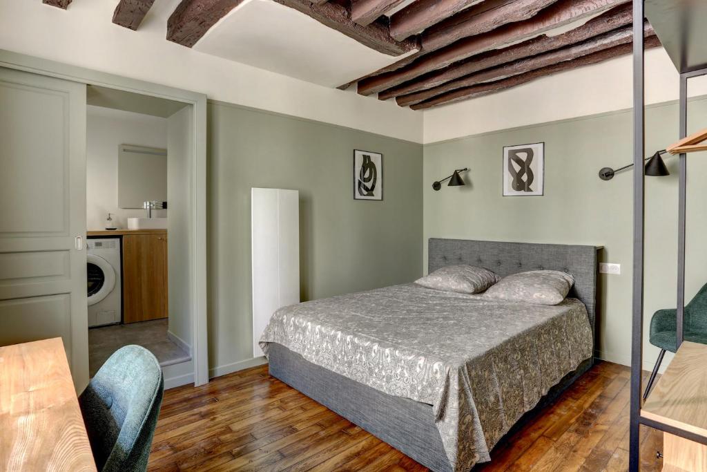 une chambre avec un lit dans une pièce dans l'établissement Le Lazare, à Versailles