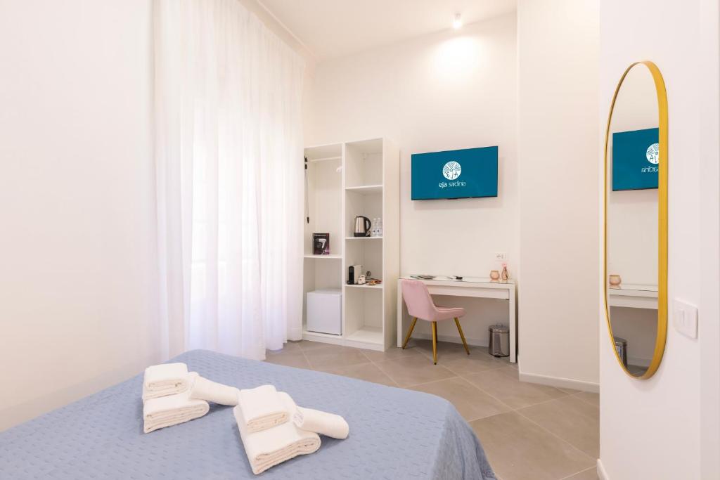 a white room with a bed and a mirror at Maddalena Rooms - Eja Sardinia in Cagliari