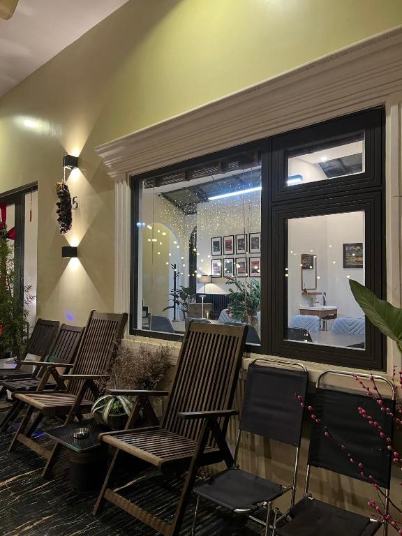 a group of chairs in a room with a large window at Villa Délight House “Stay&Chill” in Da Lat