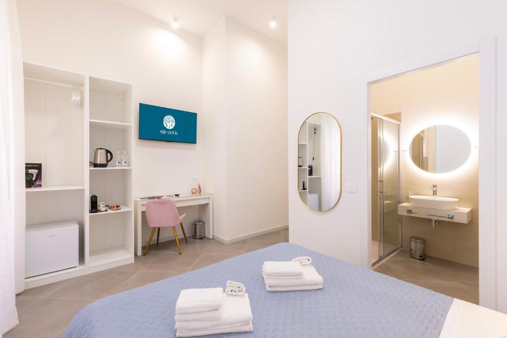 a bathroom with a bed and a sink and a mirror at Maddalena Rooms - Eja Sardinia in Cagliari