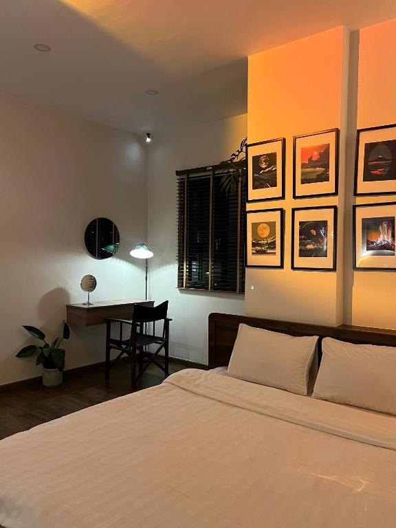 a bedroom with a bed and a table with a chair at Villa Délight House “Stay&Chill” in Da Lat