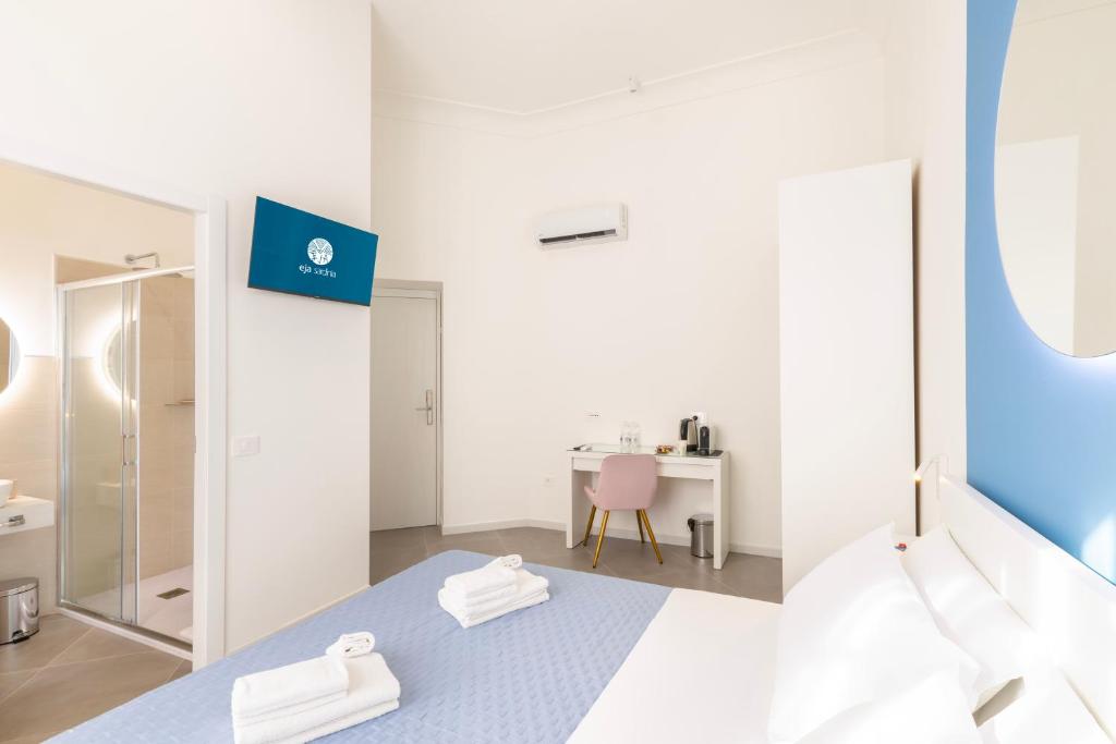 a white room with a bed and a desk at Maddalena Rooms - Eja Sardinia in Cagliari