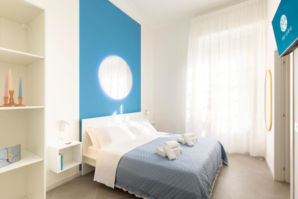 a bedroom with a bed with a blue wall at Maddalena Rooms - Eja Sardinia in Cagliari