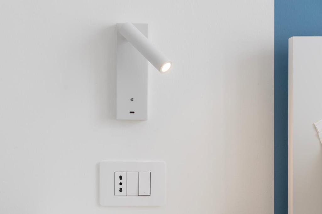 a white wall with a light on it at Maddalena Rooms - Eja Sardinia in Cagliari