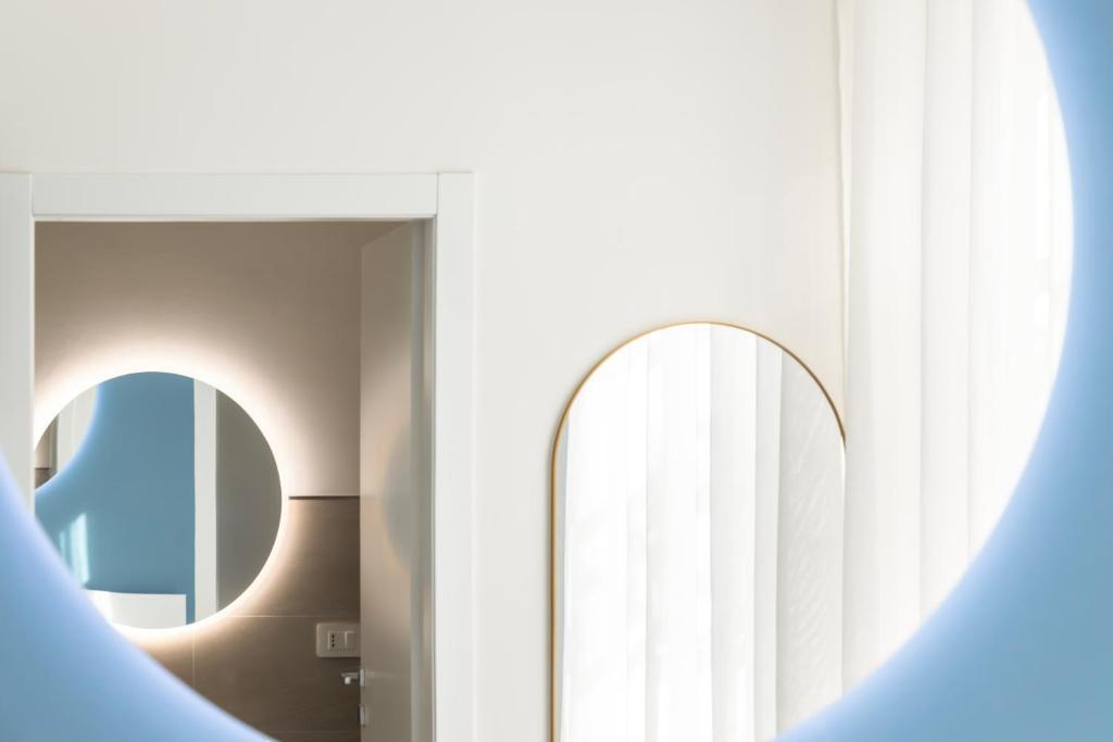 a bathroom with a mirror and a mirrorigunigunigunigun at Maddalena Rooms - Eja Sardinia in Cagliari