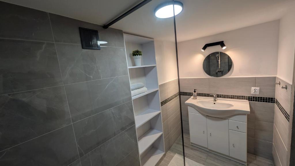 Un baño con lavabo y ducha de cristal. en Przy Strumyku - Apartament w Górach Izerskich, en Kłopotnica