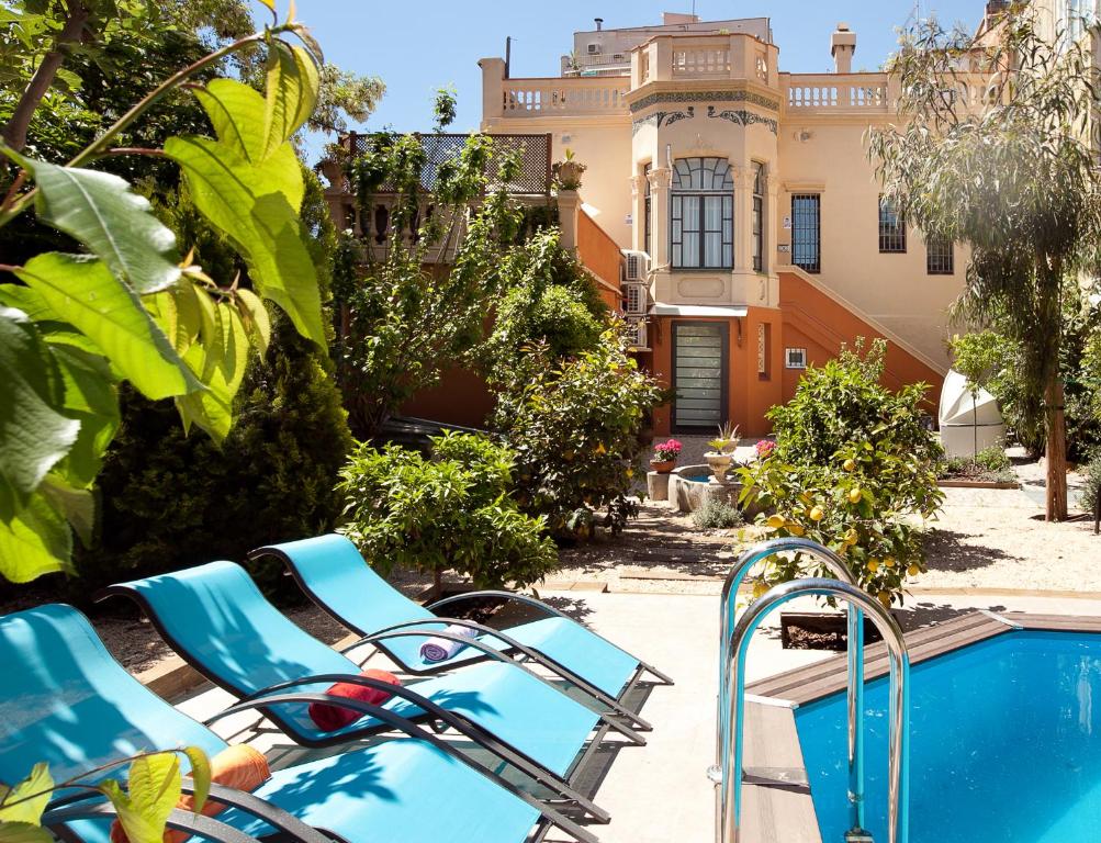 a group of chairs next to a pool with a building at Villa Modernista in Barcelona