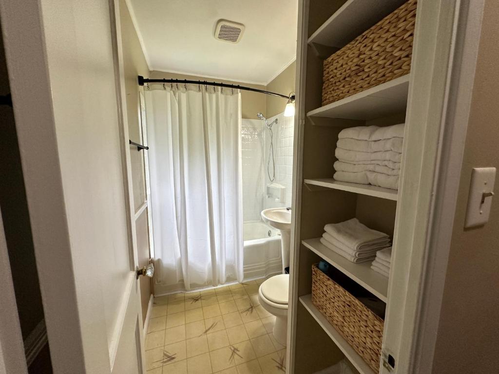 a bathroom with a toilet and a shower and towels at Cute & Cozy 2 Bedroom Near Park in Midland