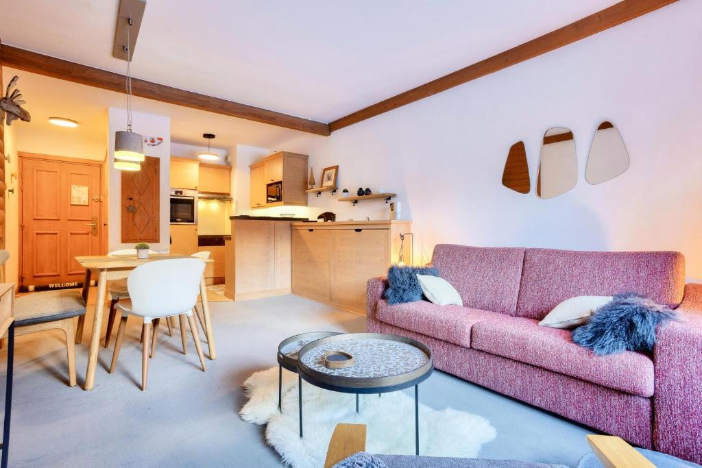 un salon avec un canapé rose et une table dans l'établissement Résidence Les Arcs 1950 Le Village - maeva Home - Appartement charmant vue montagne 2 pièces 4 personnes - Prestige - super Home MAE-9531, à Arc 1950