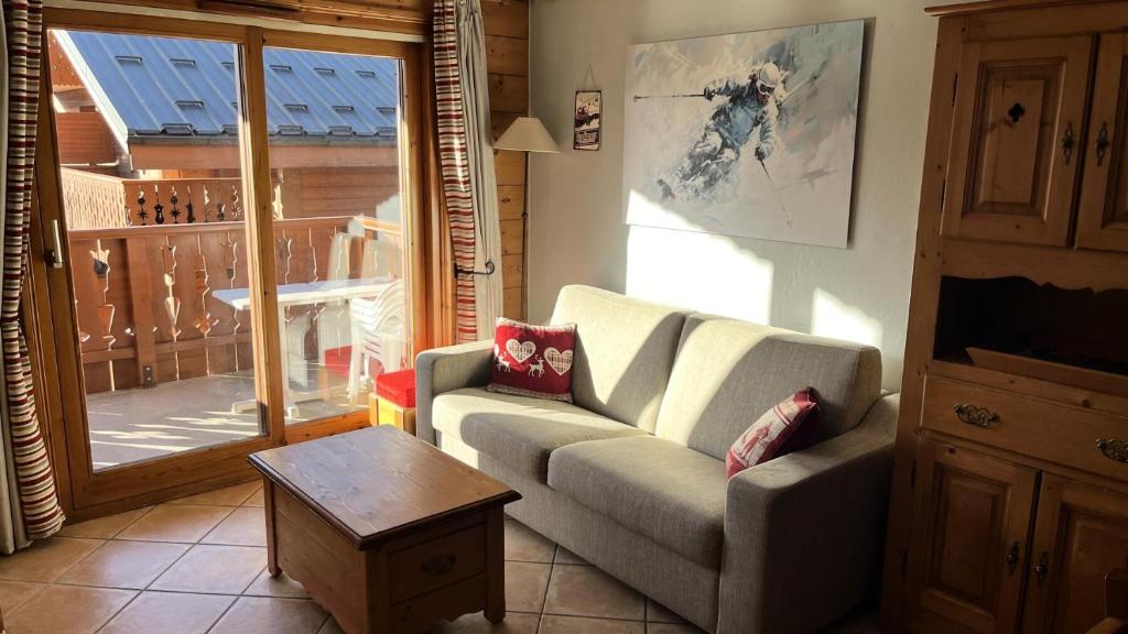 un salon avec un canapé et une table dans l'établissement Résidence Les Fermes du Soleil - maeva Home - Appartement 3 pièces 6 personnes - Prestige MAE-4281, à Arâches-la-Frasse