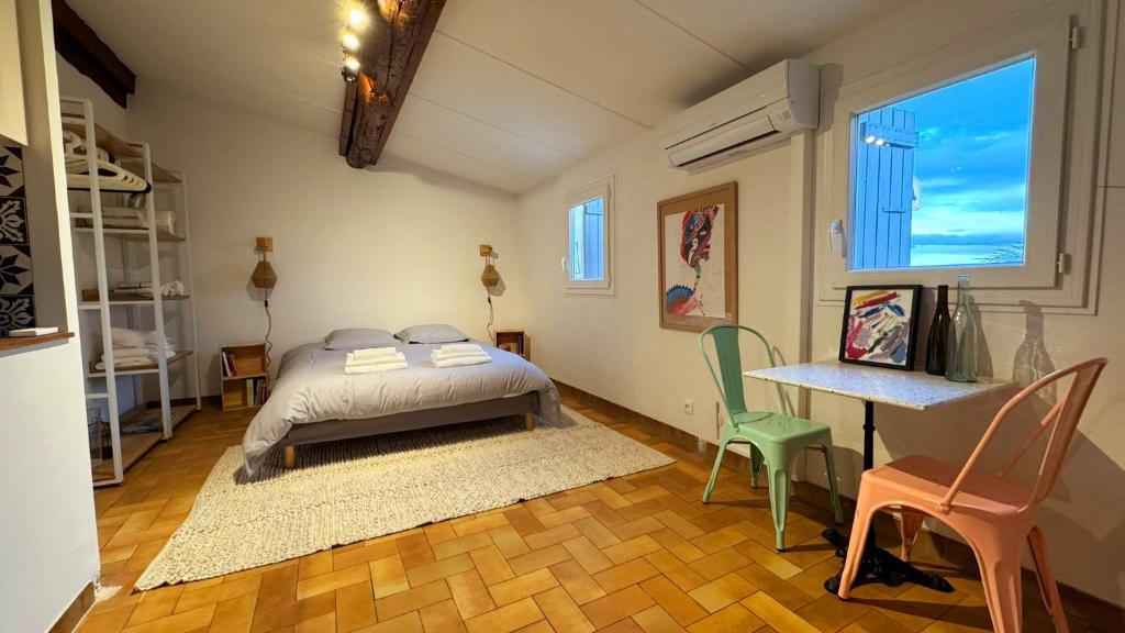 une chambre avec un lit, une table et des chaises dans l'établissement La Parenthèse Piscénoise, à Pézenas