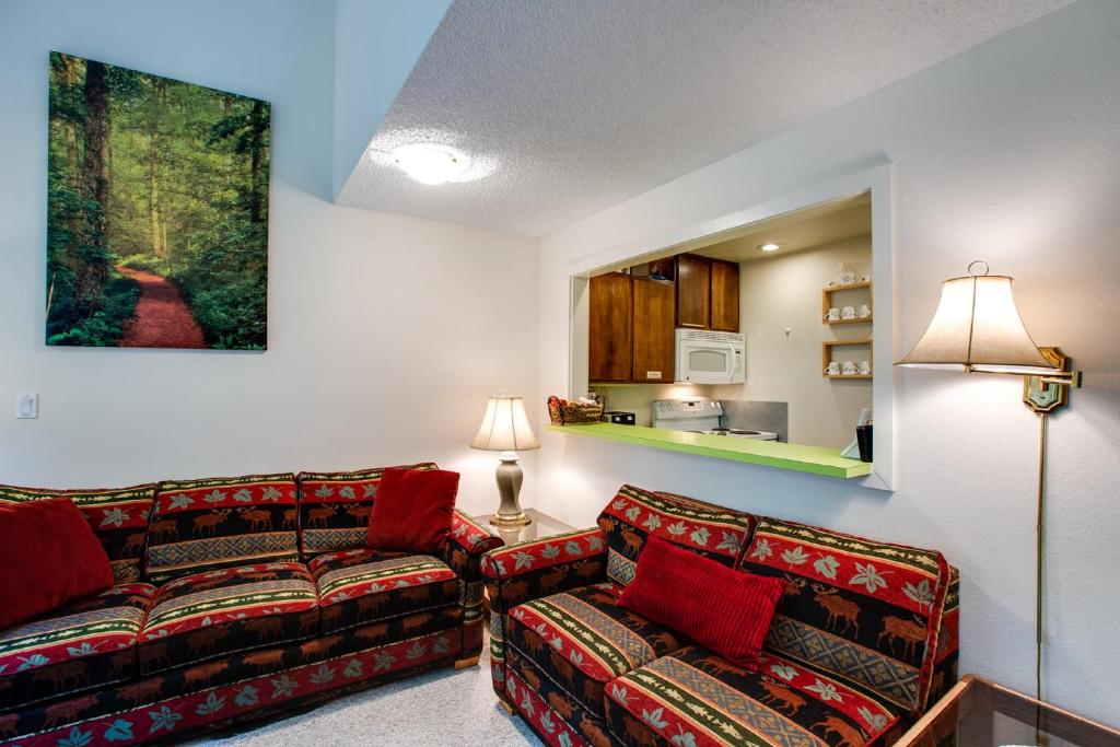 a living room with two couches and a kitchen at Snowater Condo 38 - A great mountain retreat in Glacier