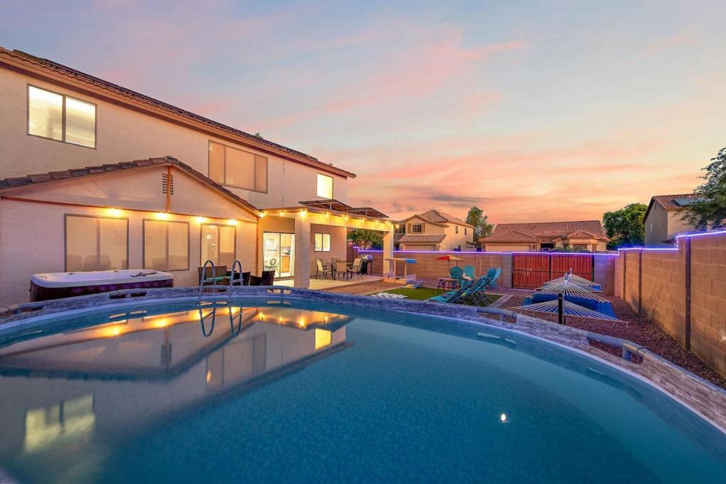 a swimming pool in front of a house at Desert Dunes sauna and spa in Casa Grande
