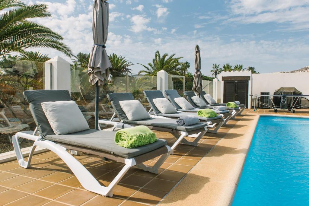 カレタ・デ・フステにあるCasa Africaのスイミングプールの横に長椅子が並ぶ