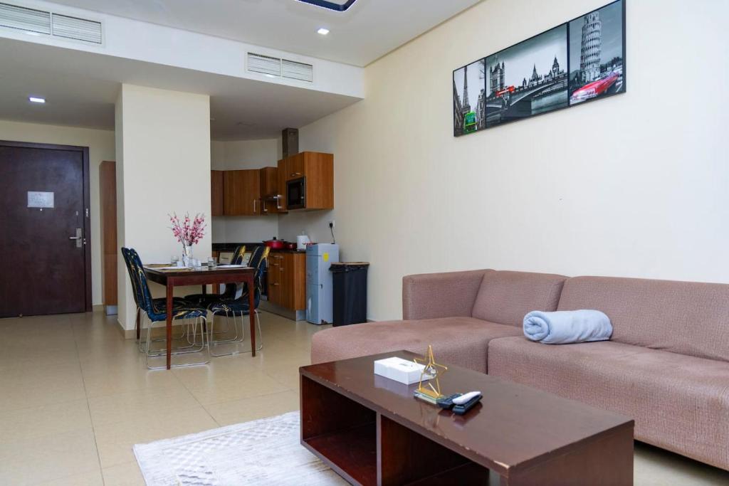 Aspire Tower - Spacious One Bedroom Apartment في المنامة: غرفة معيشة بها أريكة وطاولة