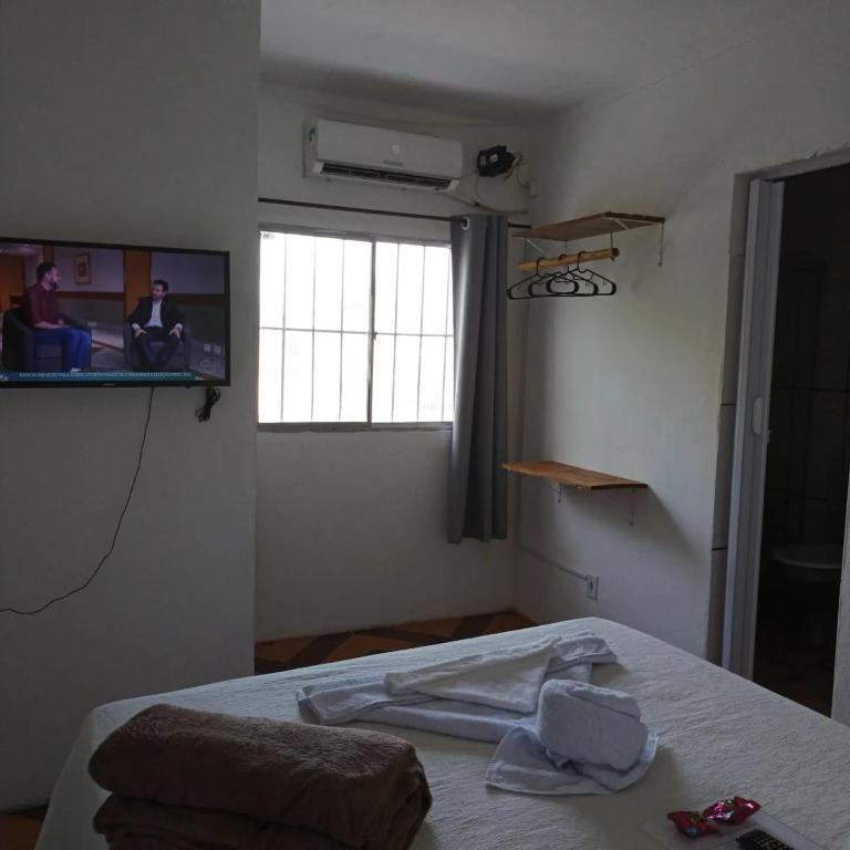 a room with a bed and a tv on the wall at Prédio AZUL in Itacaré