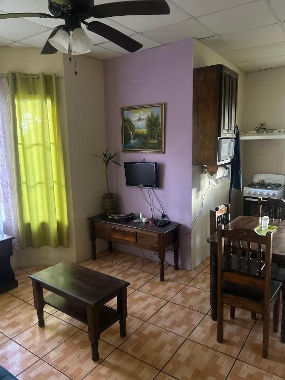 Una sala de estar con un sofá, una mesa y un televisor. en Linda Vista Cabins, en Boquete
