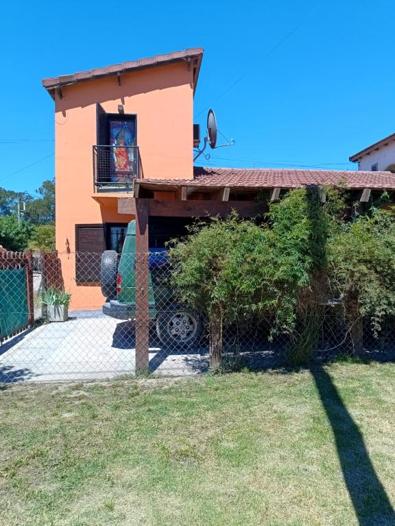 a house with a balcony and a person in the window at Alquilo casa dúplex!!! in Necochea