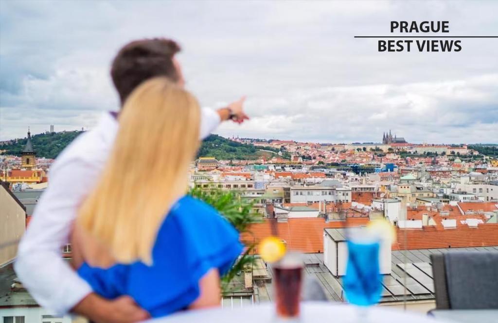 a man and a woman looking out over a city at Wenceslas Square Hotel - Czech Leading Hotels in Prague
