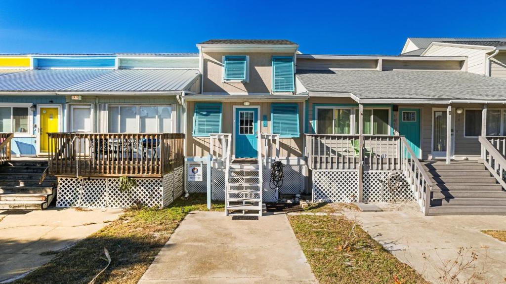 una casa con una puerta azul y un porche en Salt Therapy, en Navarre