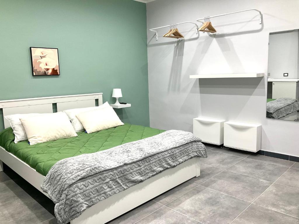 una camera con un letto verde e bianco di Siculahome23 a Catania