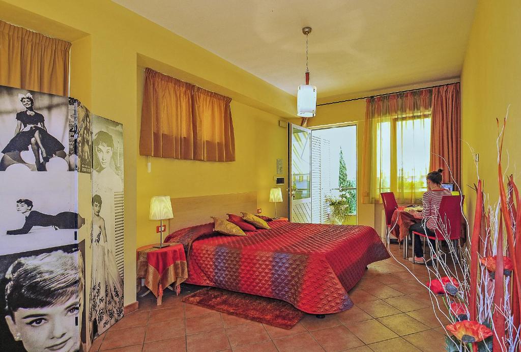 un dormitorio con una cama y una mujer sentada en una mesa en B&B Ai Cipressi, en Lucca