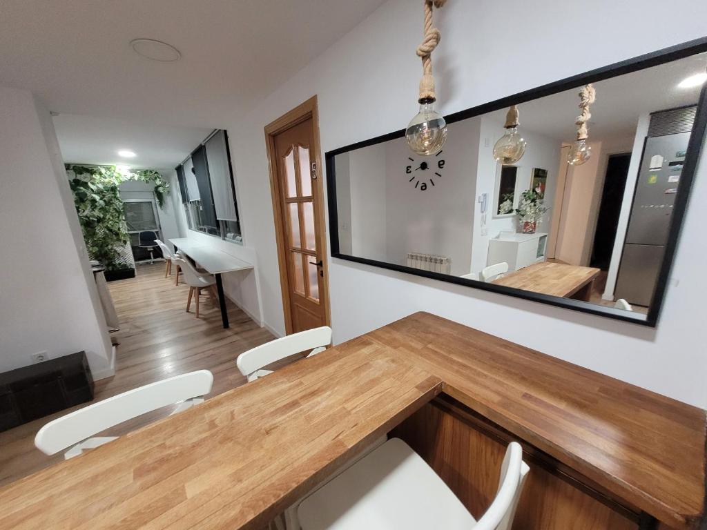 ein Esszimmer mit einem Holztisch und einem Spiegel in der Unterkunft Habitaciones con vistas Madrid in Madrid