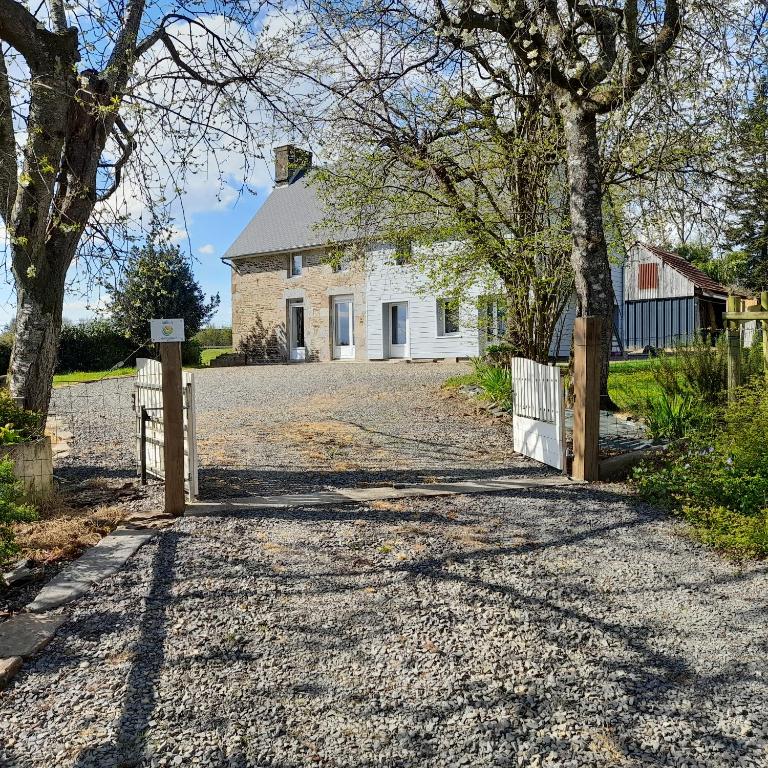 une allée menant à une maison blanche avec une clôture dans l'établissement GITE de la GAUMERAIS, à Chèvreville