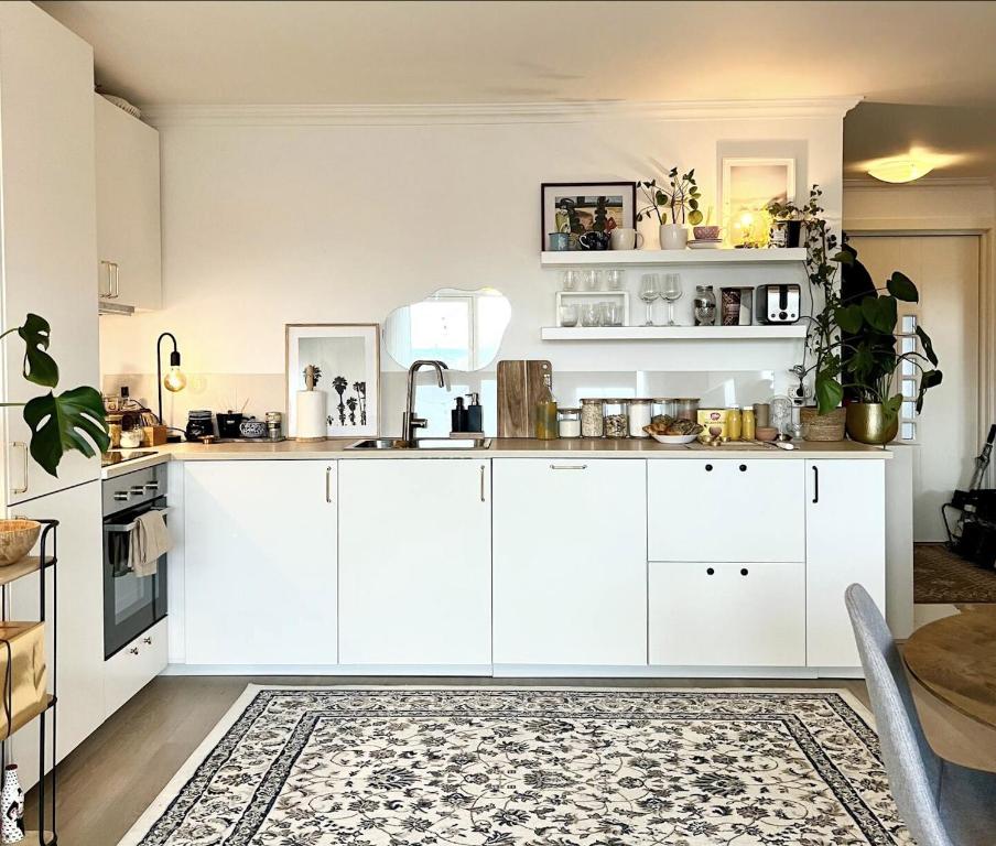 - une cuisine avec des placards blancs et un tapis dans l'établissement Cosy Room 10M to Oslo S ONLY WOMEN, à Oslo