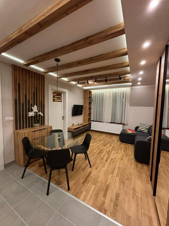 a living room with a table and chairs and a couch at Šumska staza Divčibare apartmani in Divčibare
