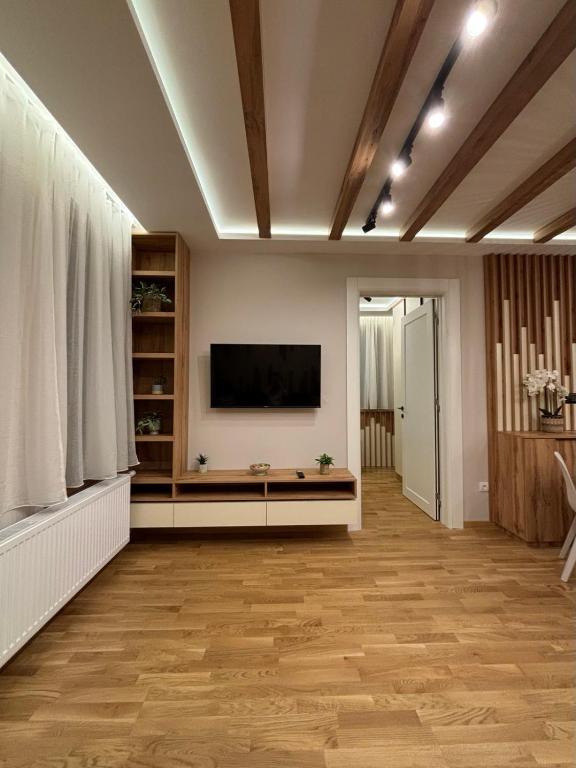 a living room with a flat screen tv on a wall at Šumska staza Divčibare apartmani in Divčibare