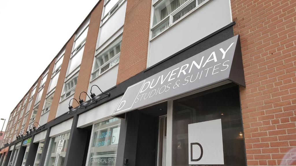 a store front of a brick building with a sign at Duvernay Studios and Suites in Gatineau
