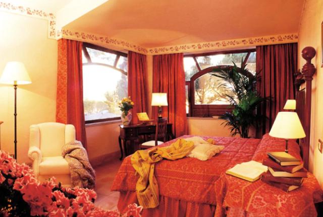 a bedroom with a bed and a chair and a window at Hotel La Locanda Dei Ciocca in Grottaferrata